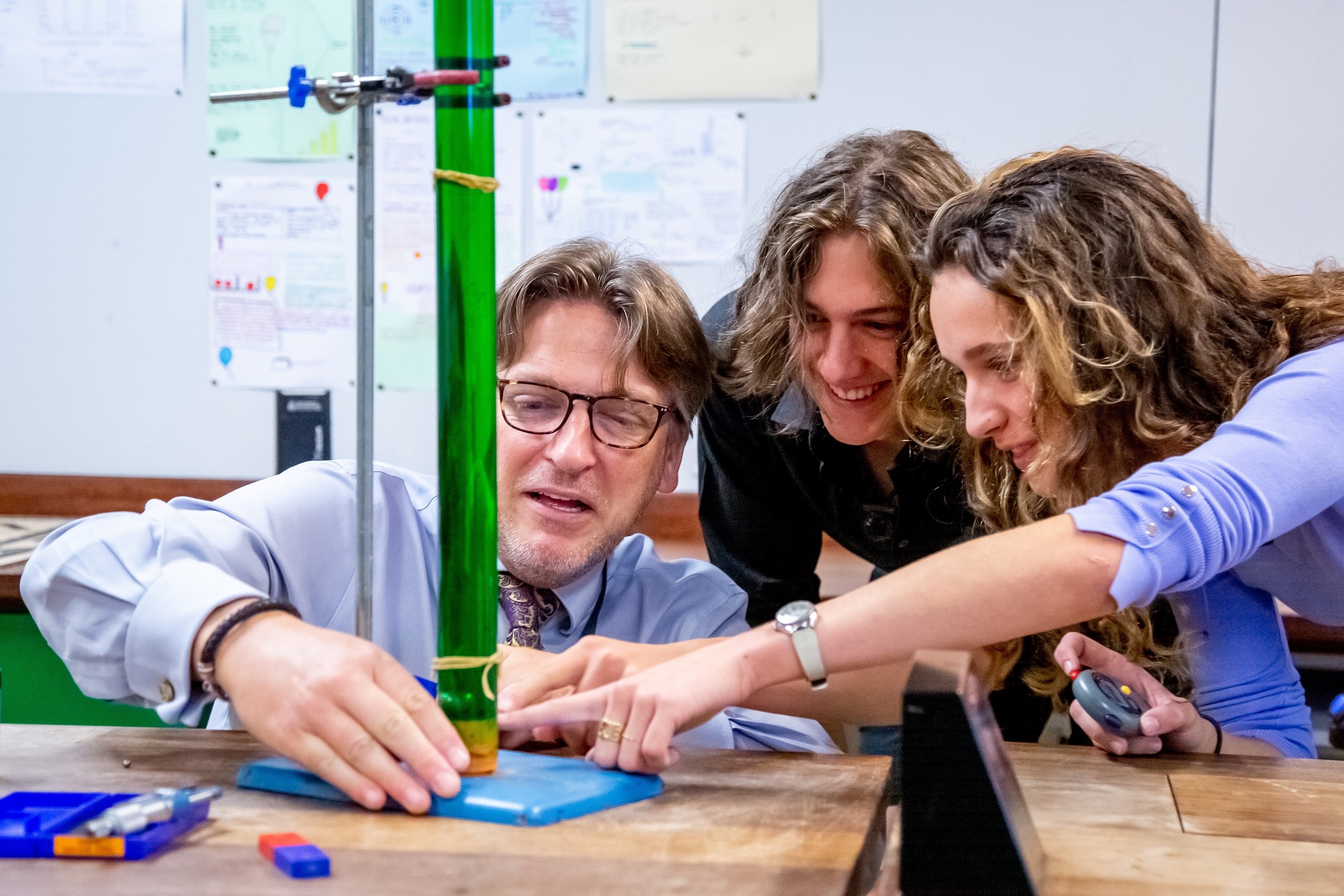 Sixth Form pupils conducting science experiment with a teacher
