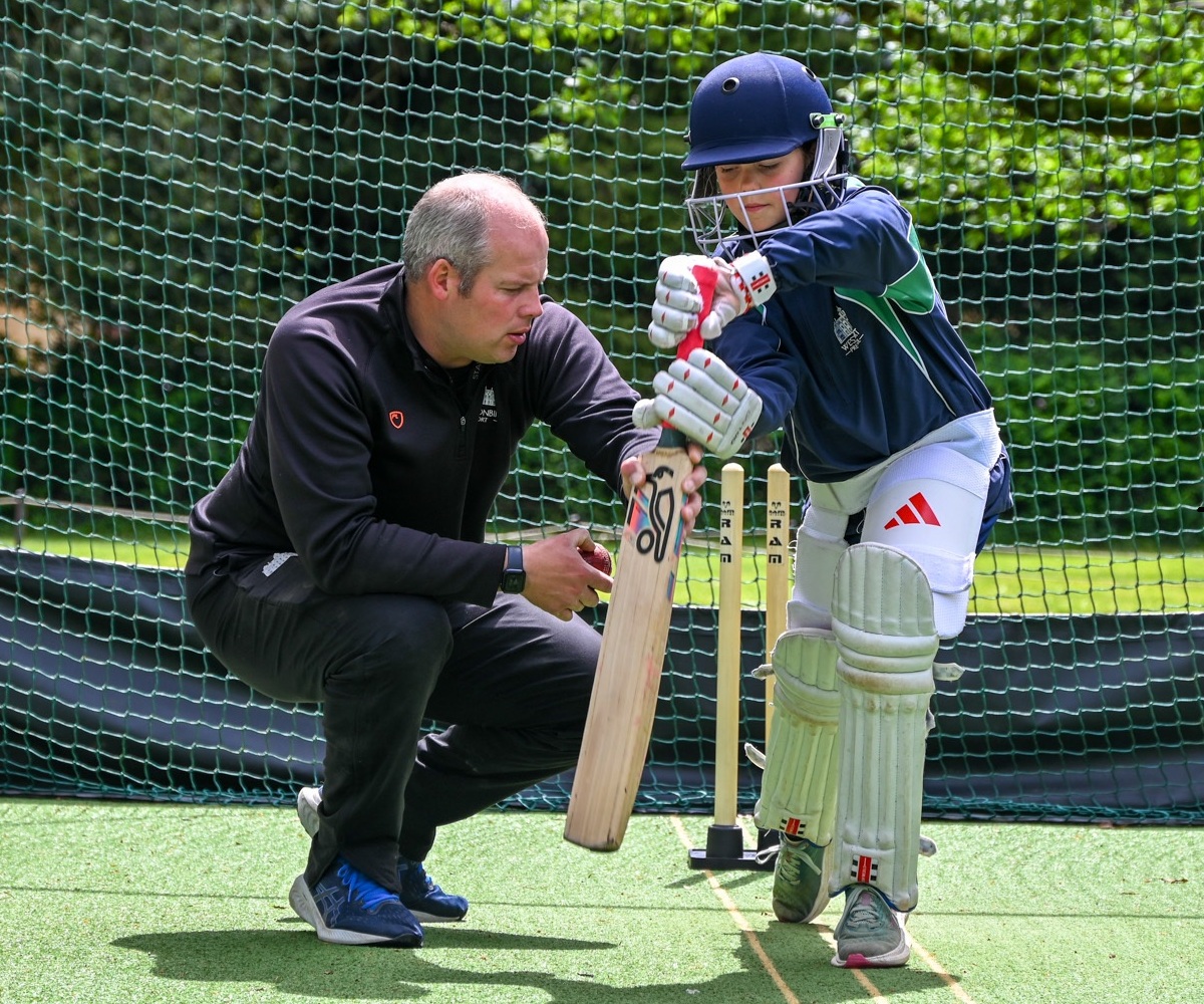 A sports teacher coaches a pupil at Westonbirt Prep School