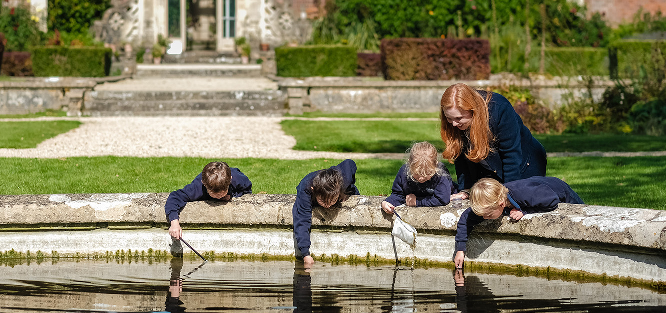 A group of Reception children at Westonbirt Prep School explore some of the water wildlife in the school's Italian Gardens